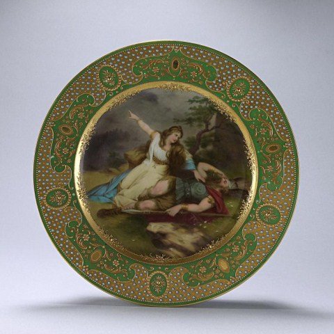 19TH C GILDED VIENNA PORCELAIN PLATE,SIGNED WAGNER: Centrally hand-painted with a scene from an opera by Wagner, Sigfried's Tod (Death), within a floral border, the plate's rim gilded, bejeweled and decorated with alternating oval and cartouche panels 