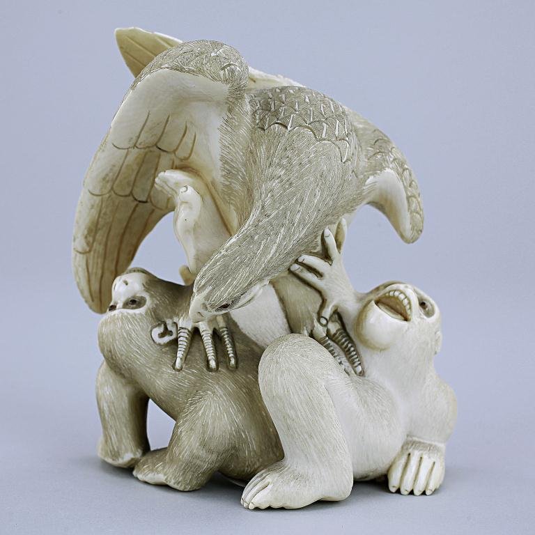 JAPANESE CARVED IVORY FIGURE OF AN EAGLE: Tokyo School. Intricately carved figure depicting an eagle and two monkeys seems like playing with each other, the eagle resting on top of the two monkeys, its claws pierced on both monkeys, one on th