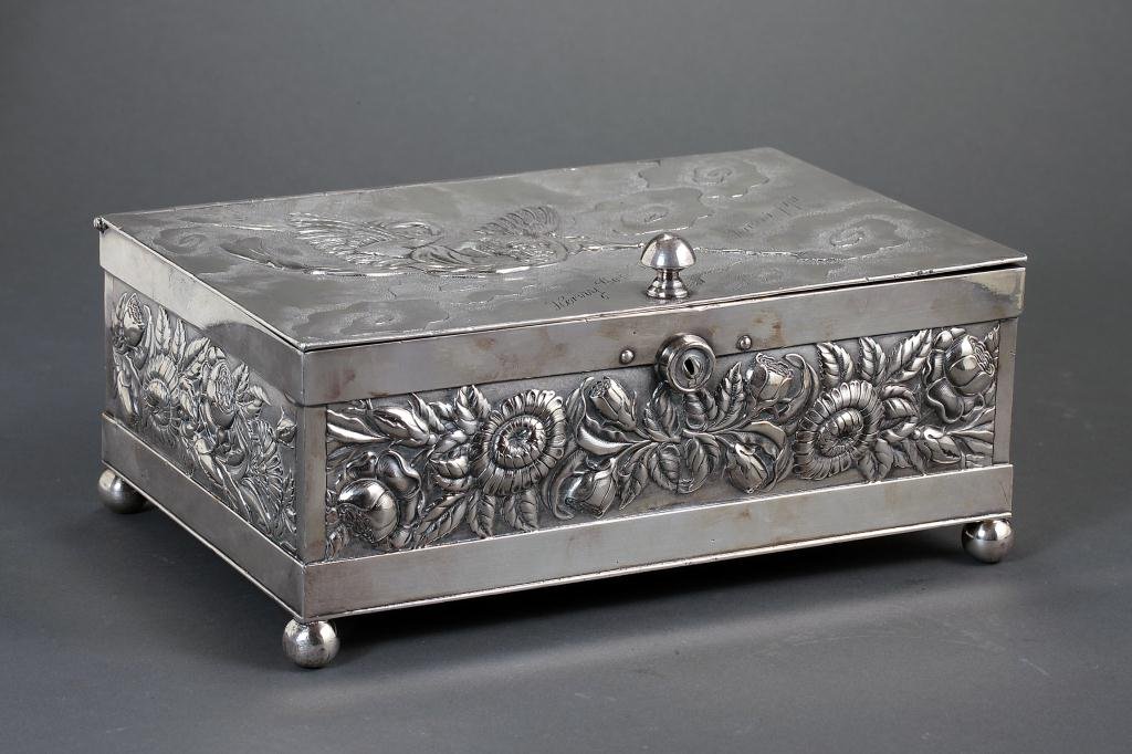 FINELY CHASED ANTIQUE DERBY SILVER-PLATED BOX: Of rectangular shape and raised on four bun feet, cast with a repousse and chasing technique, the sides designed with dense foliage, while the lid with a mythical creature holding a spear flying amids