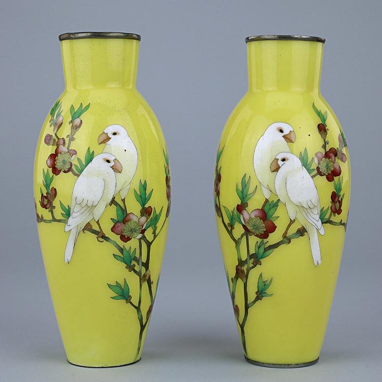 PAIR OF JAPANESE ANDO CLOISONNE VASES: Of baluster bodies with a tapering base and rising to a short cylindrical neck and brass lipped rim, vibrantly hand painted to the body with two white long-tailed birds perched on a blossoming plum tr