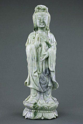 CHINESE JADEITE FIGURE OF A GUANYIN: Standing on a double lotus base wearing her flowing robe, one hand is holding a vase. H: 12 3/4 in. (32.5cm)