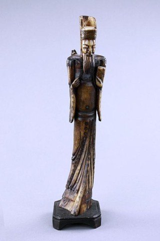 CHINESE CARVED FIGURE OF A SAGE: A tall standing elderly man in hole-pierced robe and skirt with left hand holding a tablet, a fish on its back. H:14 1/4 in.(36cm)