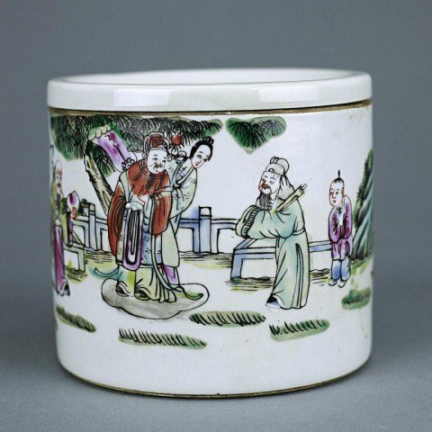 CHINESE EARLY 20TH CENTURY BOX WITH LID: Of small cylindrical form, brightly hand painted to the exterior depicting the fu lu shou in a fenced rockery setting; the lid enameled with an emblem, in between two bats, and encircled within altern