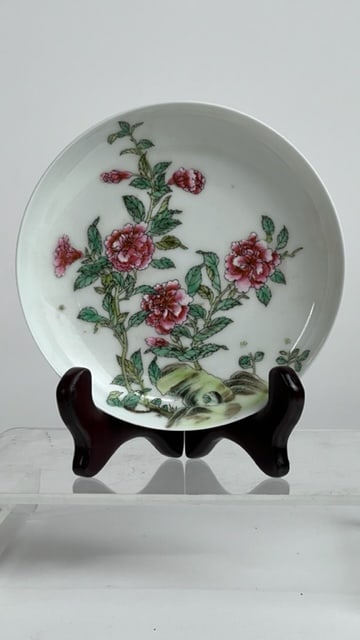 CHINESE FAMILLE ROSE PLATE: With several large and small blooms on a shrub against a white ground. Red mark in double square borders on the base. D: 5 1/2 in.