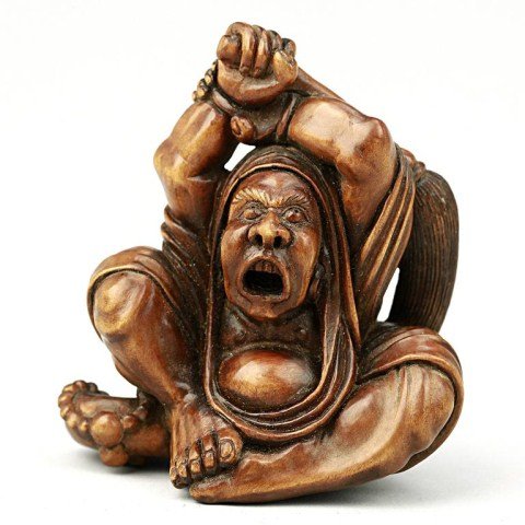 ANTIQUE JAPANESE CARVED FRUITWOOD NETSUKE: Of a seated man holding a paint brush. H: 2 5/8 in.(6.5cm)