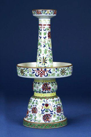CHINESE FAMILLE ROSE PORCELAIN CANDLE HOLDER: Formed in two sections, the hollow lower half of bell and globular shaped stem, and the upper half formed as a tapering neck with dish-shaped mouth rising from a large circular dish, enameled with the