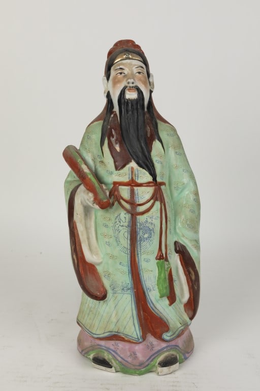 CHINESE PORCELAIN FIGURE OF A SCHOLAR: Modeled as a scholar with long, black beard, dressing in a robe and holding a scroll on his right arm.