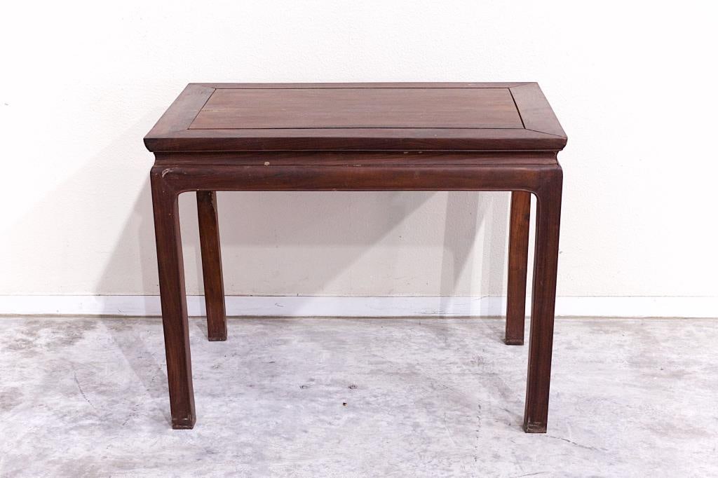 20TH CENTURY CHINESE EBONIZED HARDWOOD TABLE: In rectangular form, raised on four legs, in dark reddish brown color. H: 22 in., W: 20 in., L: 29 in.