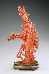 CHINESE CARVED CORAL OF A BEAUTY: The standing beauty holds flowering branches in both hands, wearing layered robes with billowy undercut scarves and an elaborate headdress. H: 8 1/4 in.