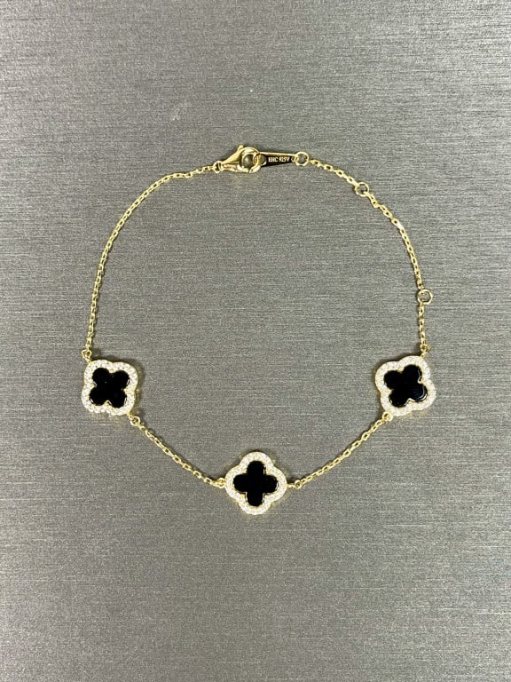 ELEGANT GOLD VERMEIL BRACELET: With three black cloverleaf motifs, encircled by zircon stones. Designed by Rachel Zoe.