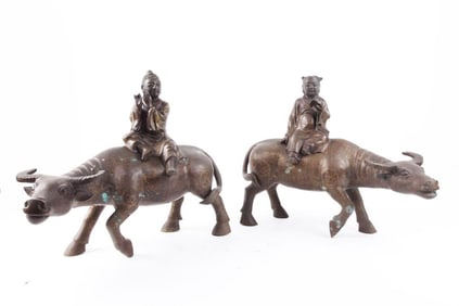 PAIR OF FIGURES OF BOYS SEATED ON BUFFALOS