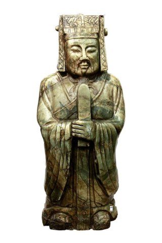 CHINESE LIGHT GREEN JADEITE FIGURE OF A SAGE: Finely carved figure of a standing Sage holding a staff, his face set in contemplation and carved with a beard, wearing long layered robes and a cloth cap. Part of a Private Collection from Beverly Hi