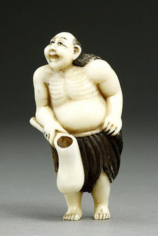 ANTIQUE JAPANESE CARVED IVORY NETSUKE OF A BEGGAR: Signature by the foot.