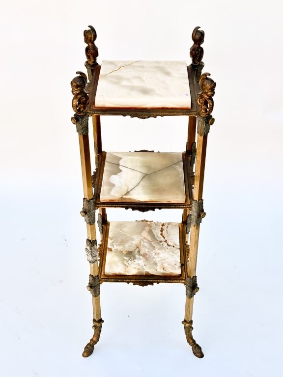 FRENCH THREE-LAYERED MARBLE AND BRONZE ETAGERE: With square top on each layer, and all four sides have finials of a putto wearing a headgear.