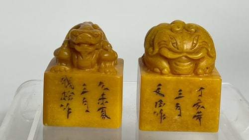 A SET OF TWO AMBER-COLORED FIGURAL STAMPS