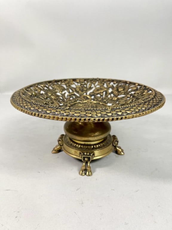 EUROPEAN GILT BRONZE CENTERPIECE: Raised on four legs, flanked by a round reticulated plate atop with floral motif, decorated with a god in center. H: 5 1/2 in. Diameter: 5 1/2 in.