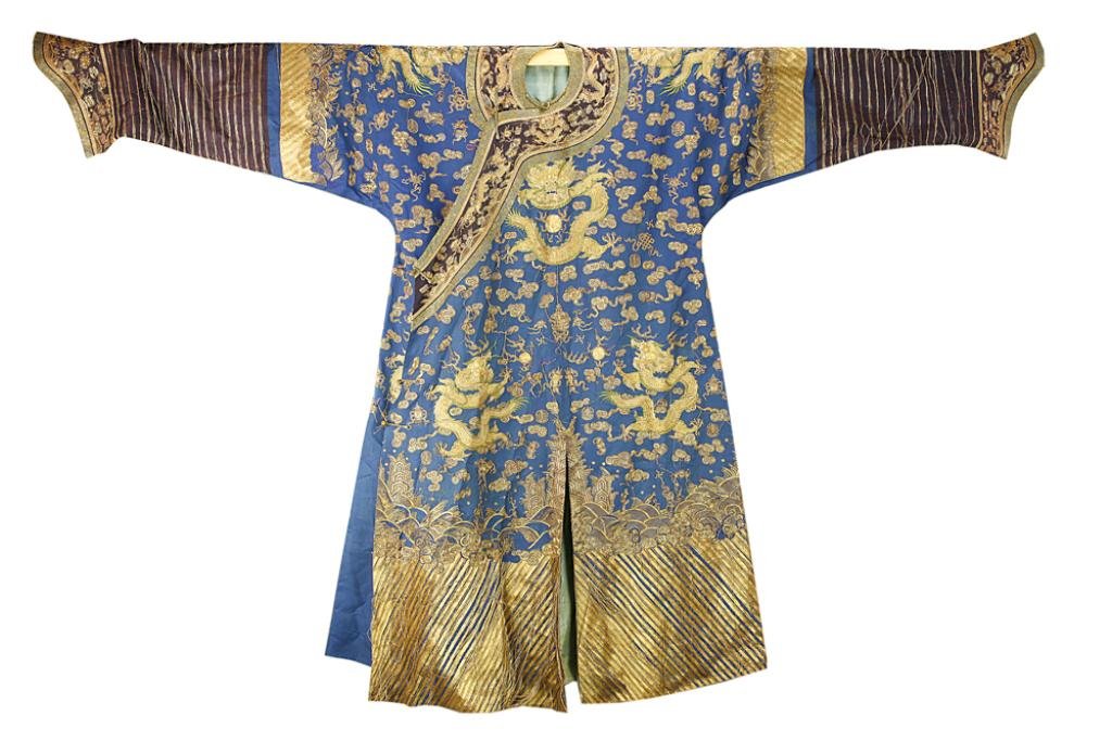 CHINESE IMPERIAL DRAGON ROBE: Dragon robe of blue background with five-clawed dragons in gold couching amidst clouds, swastikas, shou symbols, bats and ribboned auspicious Buddhist emblems over crashing waves and mountains. The cu