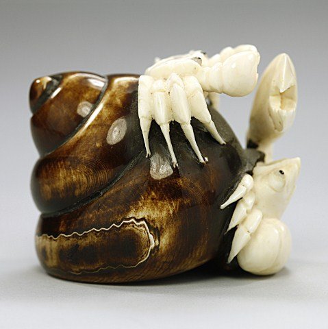 ANTIQUE JAPANESE CARVED IVORY NETSUKE: of a crab crawling on top of a hermit crab. H: 1 3/4 in.