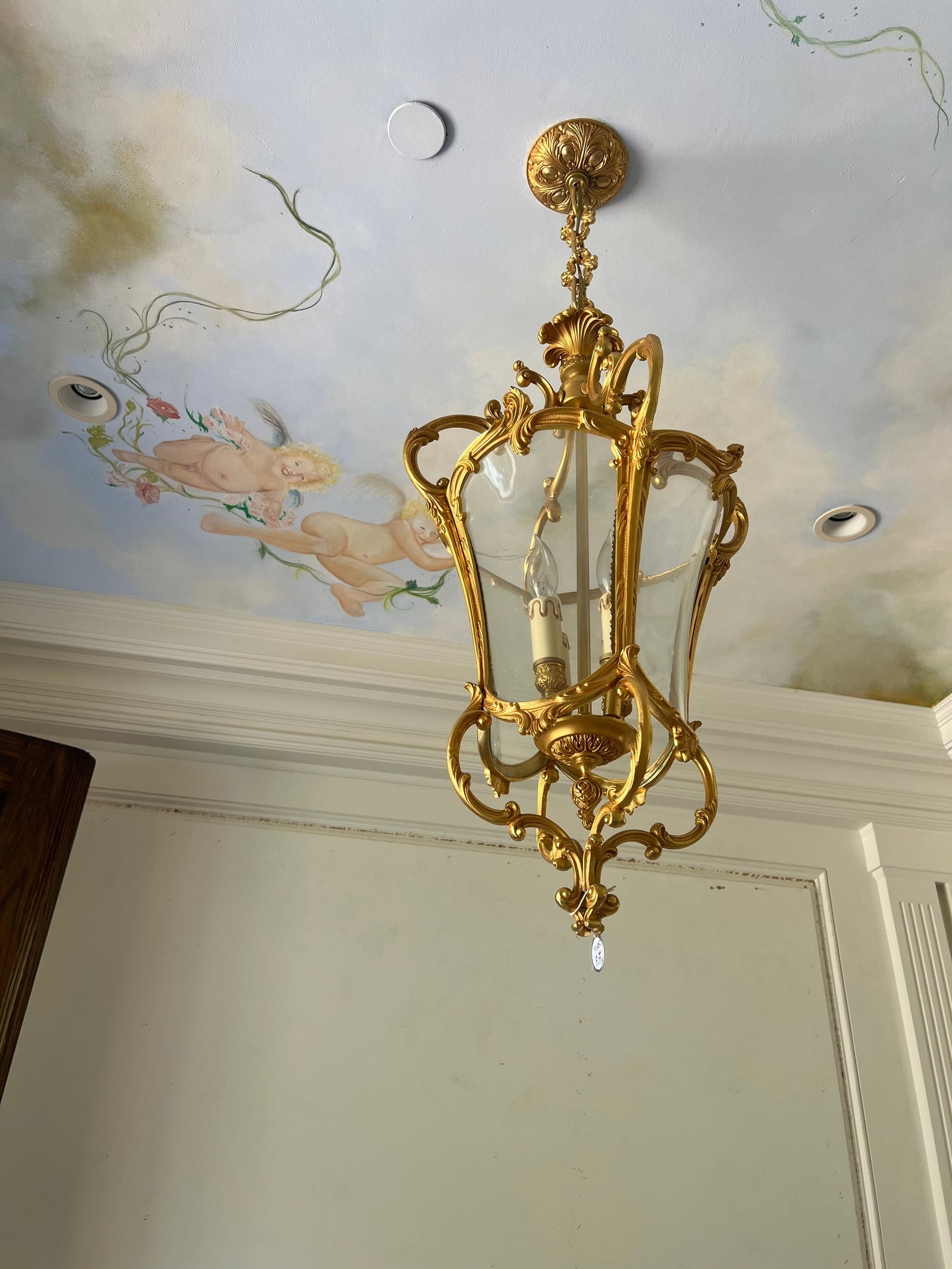 FRENCH-STYLE GILT BRONZE HANGING ENTRANCE LANTERN: Dimensions: H: 28in. Featuring a Rococo-influenced style, typical of the Louis XV or Empire revival styles. Gilded frame has ornate scrollwork, acanthus leaf accents, and decorative cartouches. The la