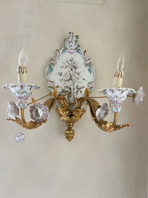 A PAIR OF PORCELAIN WALL SCONCES: Dimensions: H: 21in. x W: 19in. Matching style with Inventory 91484 - Chandelier. This pair of two-light wall sconces features hand-painted porcelain central plaques and candle light cups with details