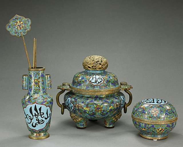 CHINESE CLOISONNÉ ENAMEL FIVE-PIECE IMPLEMENTS: Comprising of a bronze chopsticks, hair accessory, vase with tube handles to the sides, a lidded tripod censer and a round box with cover. H: 6 1/2 in.