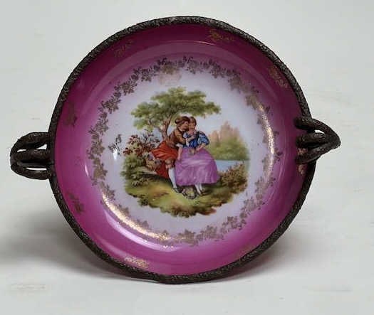 GERMAN PORCELAIN AND BRONZE CENTERPIECE: Beautifully painted in the center of a courting scene, with a signature to read Fragonard, possibly inspired by the romantic Rococo works of French artist, Jean-Honore Fragonard, against a pink backgr