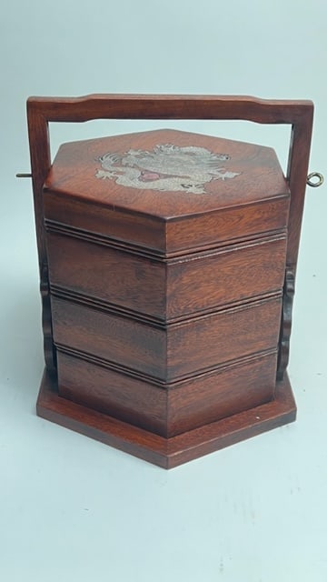 CHINESE TIERED HEXAGONAL WOODEN BOX: With a handle; inlaid with mother-of-pearl on the cover with a dragon. Each tiered box has a carved stone bi.