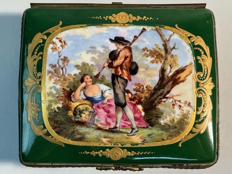 BEAUTIFUL GREEN PORCELAIN JEWELRY BOX: On the hinged cover, painted with a lover's scene with gilt details all over. Mark on the bottom. L: 5 in. H: 4 in.