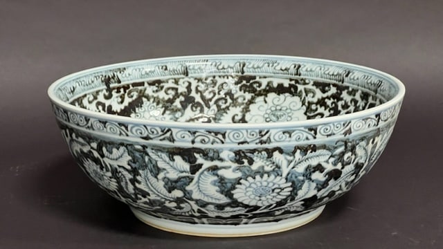 CHINESE BLUE AND WHITE BOWL: Of concave form, raised on a short leg. Depicting of meandering blooms and tendrils. H: 5 1/2 in. D: 15 3/4 in