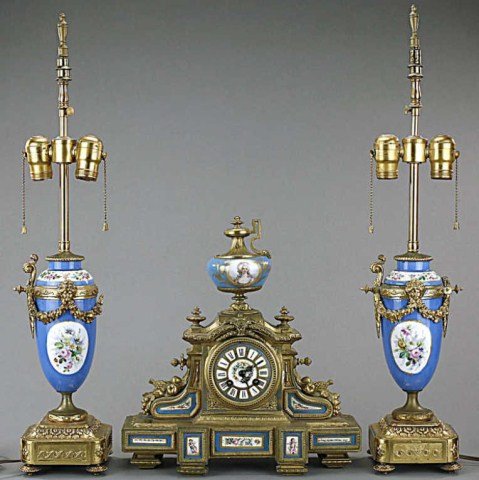 FRENCH THREE-PIECE MANTEL CLOCK SET: A porcelain and metal garniture clock set with gilt gold ornamentation and fine hand-painted cherubs on the side. H: 14 in.