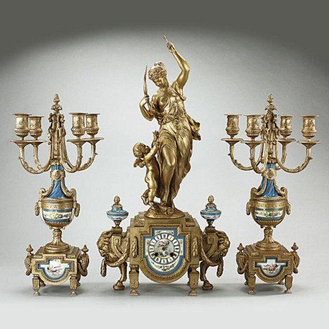 FRENCH PORCELAIN AND GILT-METAL GARNITURE CLOCK SE: French garniture mantel clock set and pair of four-light candelabras. The porcelain dial clock is surmounted by a metal sculpture of a neoclassic maiden accompanied by a cherub. The two candelabra sid