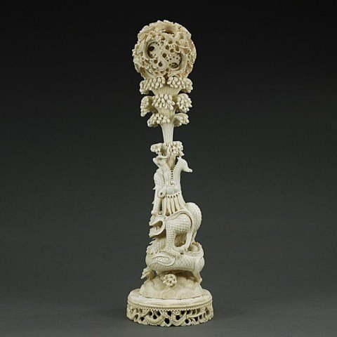 CHINESE CARVED IVORY FIGURE OF A DRAGON: A fine carved ivory dragon with carved water coming out of his mouth, supporting a puzzle ball. H: 15 in.