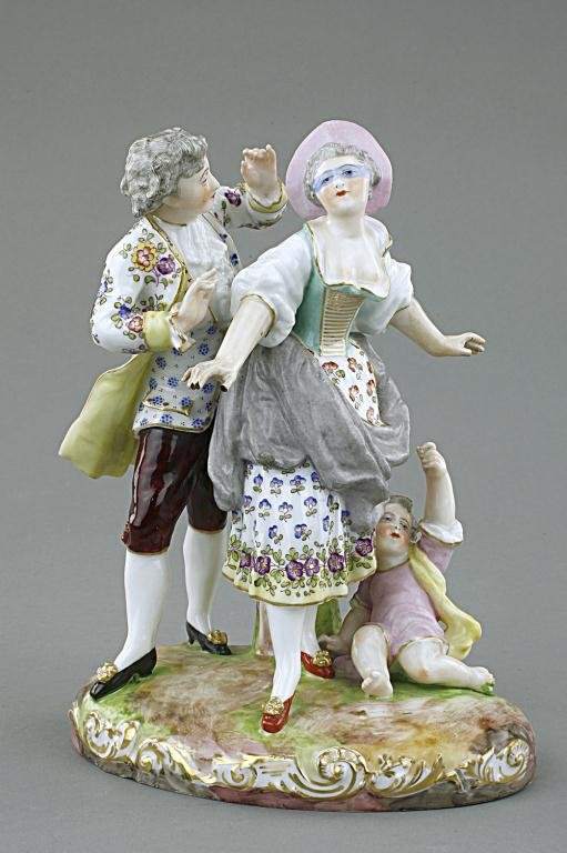 PORCELAIN FIGURAL GROUP OF LOVERS AND A CHILD: Featuring a vivid moment of a young couple/lovers playing hide and seek with a boy lying next to the lady. The decorative floral pattern is delicately applied. Blue under-glaze crossed mark on the bas