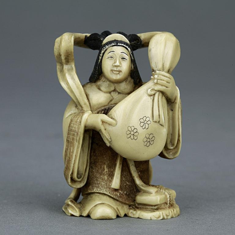 ANTIQUE JAPANESE CARVED IVORY NETSUKE: From the Private collection of Mr. Paul Siegal. Figure of a lady holding a bag. H: 2 in.(5cm)
