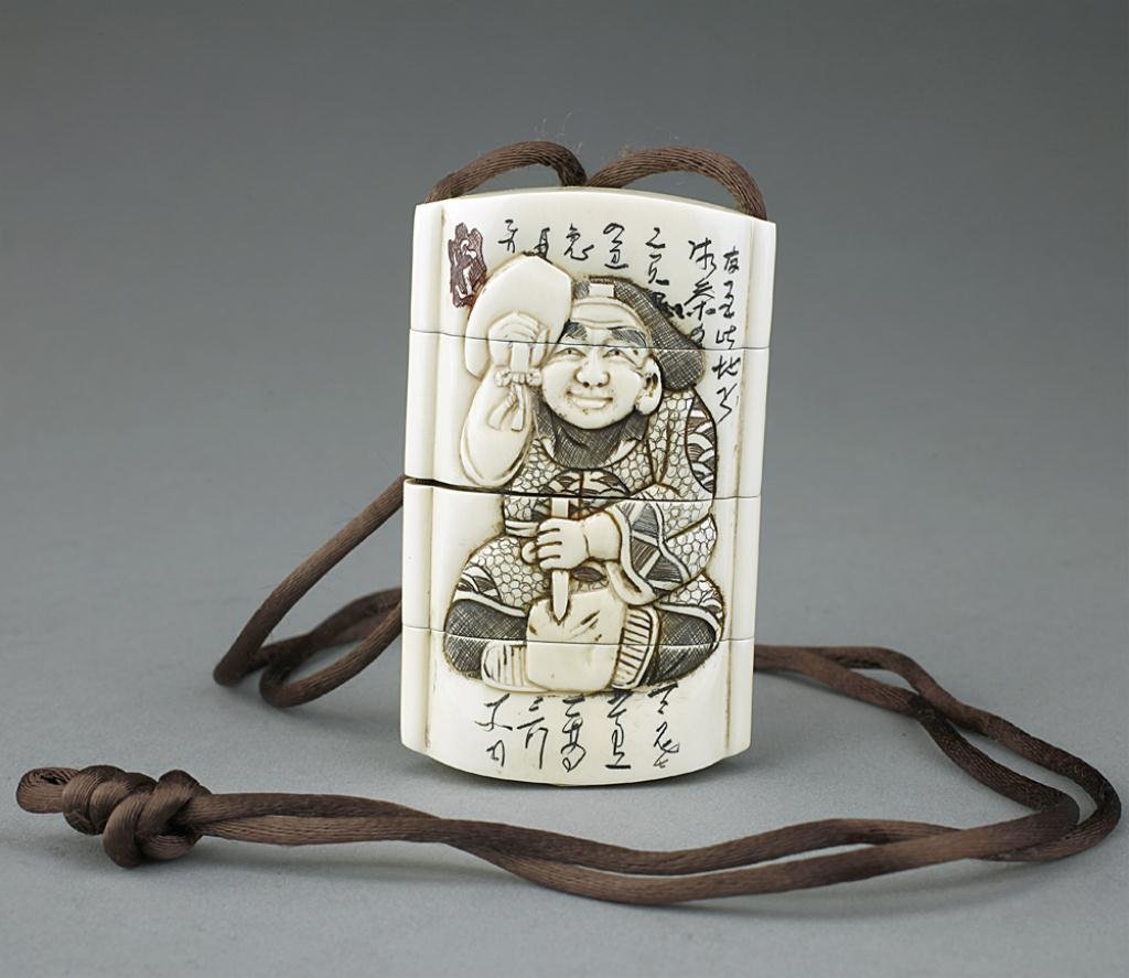 JAPANESE IVORY INRO: With four sections and three compartments, carved with a seated man in robe holding fans with ribbon, and surrounded with calligraphy, flowers on branches on the back panel. H: 2 3/4 in. x W: 1 3/4 in