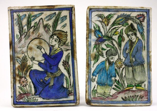 PAIR OF PERSIAN TILES: With a woman holding a tambourine and an old man with a young woman. The figures are raised from the tile base and heavily colored under the glaze. H: 7 5/8 in. x W: 5 1/8 in.