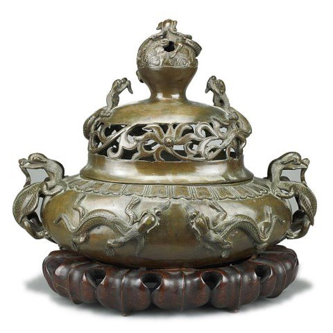 CHINESE BRONZE LIDDED INCENSE BURNER: Decorated with two chilongs as handles on the sides, a pair of chilongs on either side of the body, two on the lid, and one wrapped around the large pierced finial ball. H: 13 3/4 in.