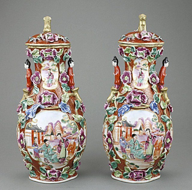 PAIR OF CHINESE FAMILLE ROSE LIDDED VASES: Decorated with molded leaves and flowers in relief and on the faces of the two sides are intimate scenes of a young couple. The shoulders are decorated with three-dimensional girls in red. Golden foo 