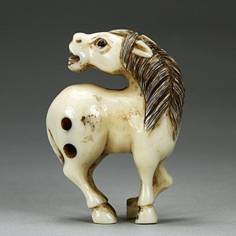 ANTIQUE JAPANESE NETSUKE OF A HORSE: Standing with its head turned to look behind it. Stained details. Signature on the bottom hoof. H: 1 7/8 in.