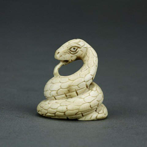ANTIQUE JAPANESE IVORY NETSUKE OF A SNAKE: From the Private Collection of Mr. Paul Seigel. Snake is coiled up with its tongue out. Signature underneath. H: 1 1/8 in.