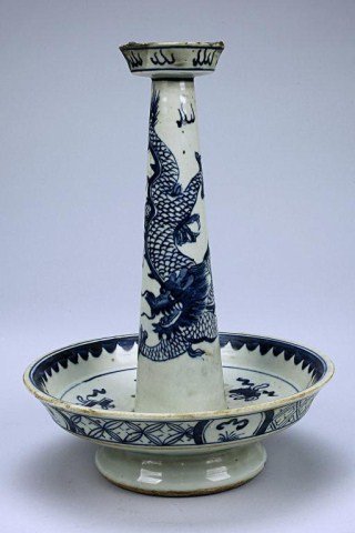 CHINESE BLUE AND WHITE CANDLE STICK: with a flattened saucer dish decorated with a band of geometric patterns around the exterior and the "eight Buddhist Emblems" in the interior and an upright candle stick painted with a dragon chasing 