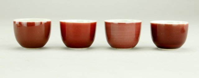 SET OF FOUR COPPER-GLAZED CHINESE TEA CUPS: Of a fine deep maroon monochromatic tone to the exterior and a creamy tone to interior. H: 1 3/4 in., D: 2 1/4 in.