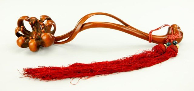 CHINESE CARVED WOOD SCEPTER: Finely polished and delicately carved with a floral bloom to one side. With an attached red tassel. L: 13 3/4 in.