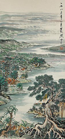 CHINESE SCROLL PAINTING OF A COASTLINE: Lush foliage lines the banks. Signature to read Guan Shanyue (1912-2000). Dated 1983. H: 38 1/4 in. x W: 19 in.
