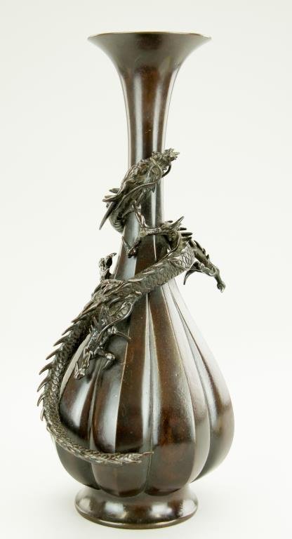19TH CENTURY JAPANESE BRONZE RAISED DRAGON VASE: A three-claw scrolling dragon wraps around the foliate body vase. Mark to the bottom. Previously set as a lamp. H: 13 3/4 in.