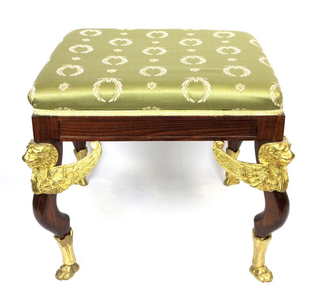 EMPIRE STYLE STOOL WITH GREEN UPHOLSTERY: EMPIRE STYLE STOOL WITH GREEN UPHOLSTERY On four s-curve legs with applied gilt bronze winged lion busts to the top and on gilt bronze paw feet. From the Marlin collection of Beverly Hills, CA. L: 20 