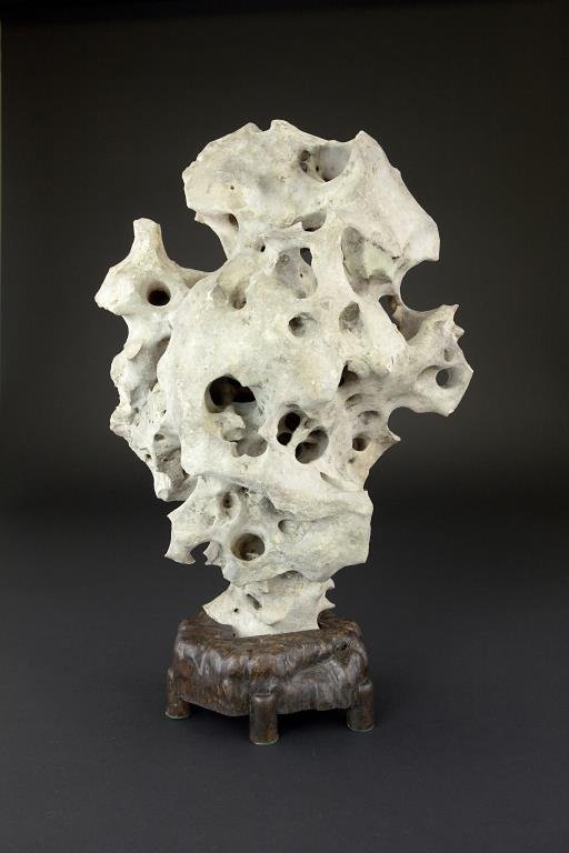 CHINESE SCHOLAR'S ROCK: CHINESE SCHOLAR'S ROCK Reticulated, the stone tapers and rests atop a carved wooden stand. From the Marlin collection of Beverly Hills, CA. H: 17 1/2 in.