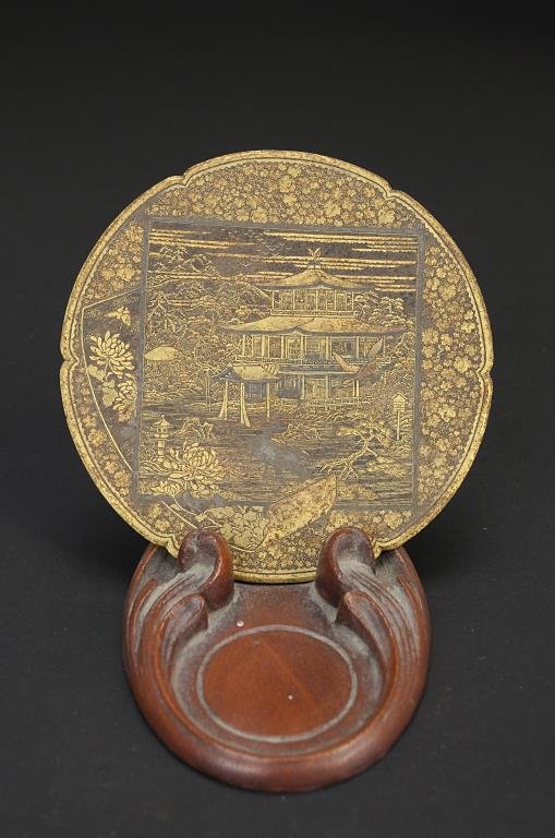 ANTIQUE JAPANESE KOMAI BRONZE DECORATIVE DISH: ANTIQUE JAPANESE KOMAI BRONZE DECORATIVE DISH Decorated in gold with image of a pavilion and lush garden in a square plaque; scrolled paper with chrysanthemums peeking from behind it; leaf pattern bac