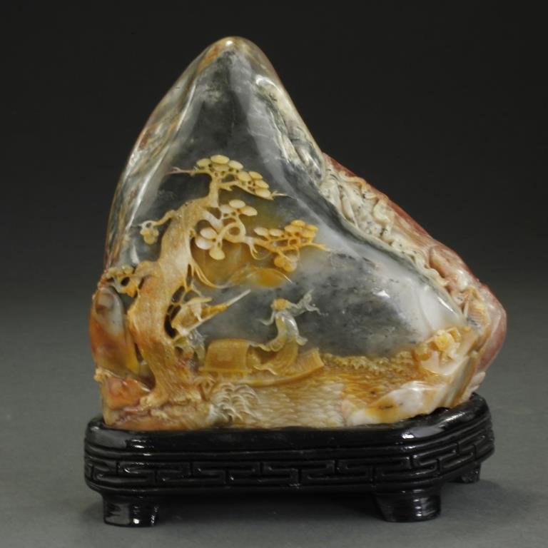 CHINESE CARVED SOAPSTONE BOULDER: Scenes of figures in landscapes carved in high relief on both sides. In a yellow, red, white, and black coloring. H: 5 1/4 in.