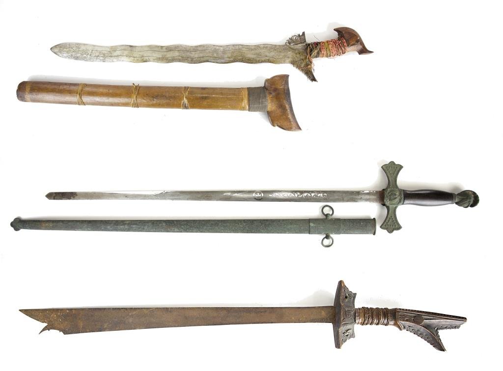 GROUP OF THREE INDONESIAN SWORDS: Two with carved wood handles; one with bronze handle and knight's head decoration. L: 40 1/8 in.